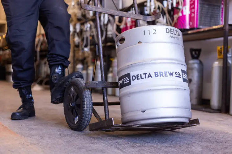 Barril de chopp Delta Brew Co. num carrinho de carga, no galpão da Porto Chopp
